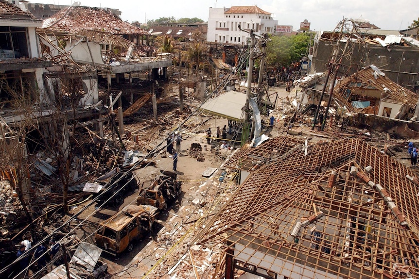 An aerial photo reveals the damage to several buildings, including completely destroyed buildings, along a narrow street.