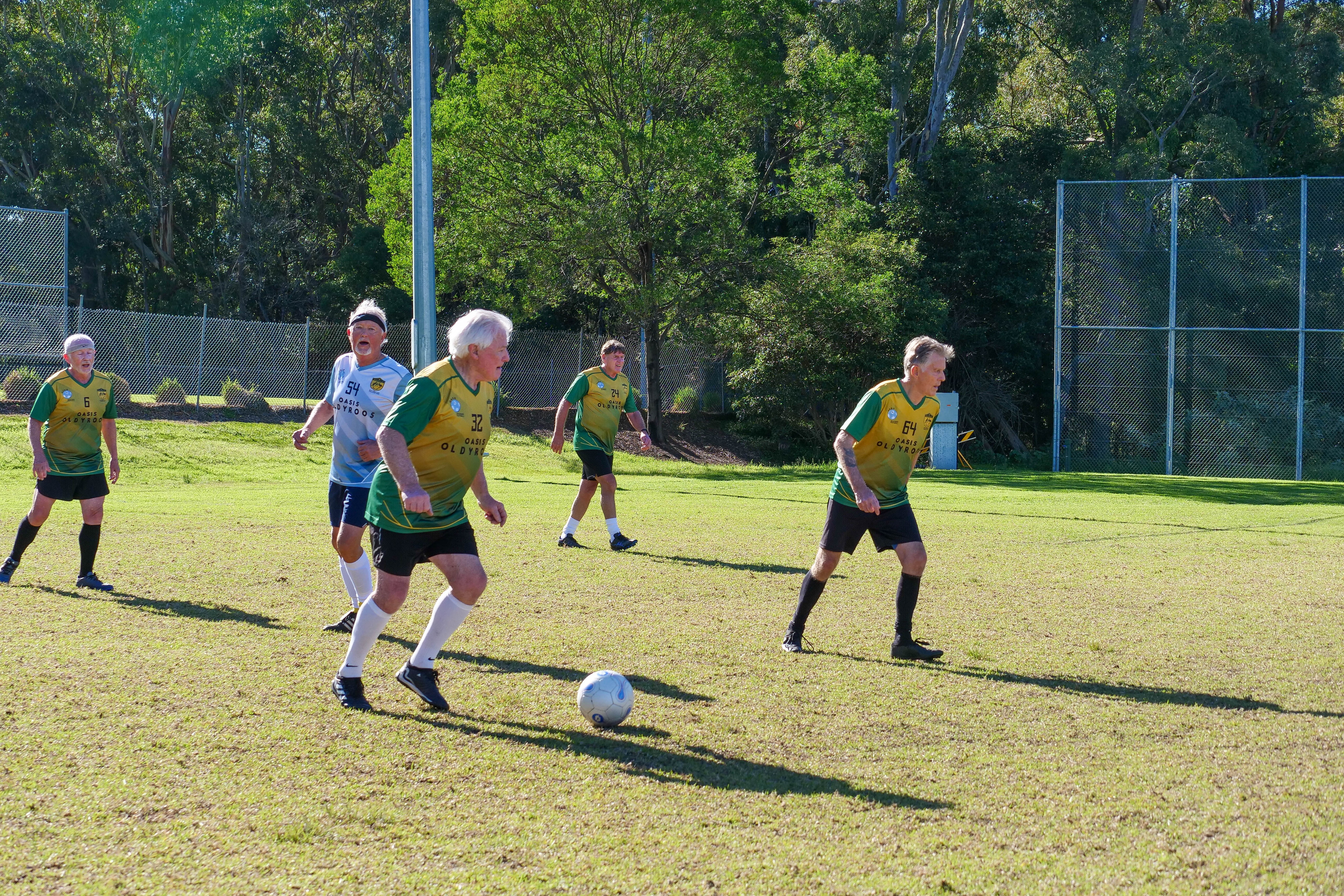 older players pass the ball in a soccer game