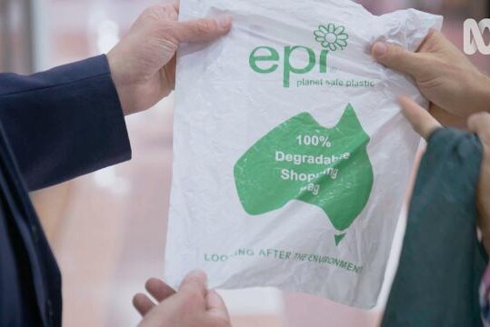 Hands hold biodegradable plastic bag to show logo