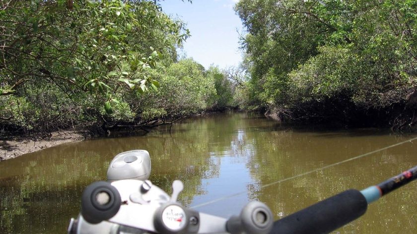 A fisherman sits with his rod and reel