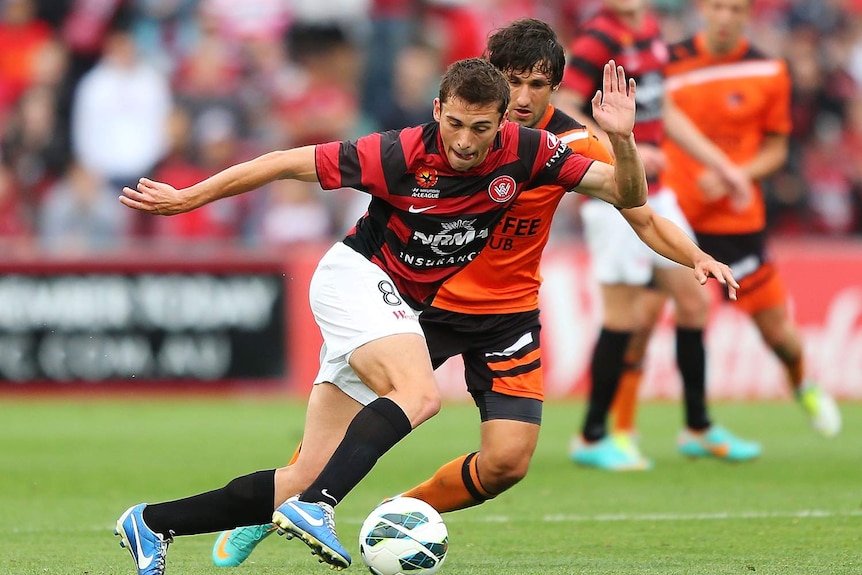 The Wanderers' Mateo Poljak competes with Brisbane's Thomas Broich.