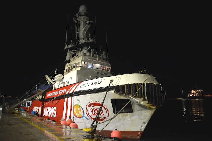 A photo of the Open Arms aid ship from the fornt. It's body is red and the front of the ship is white.