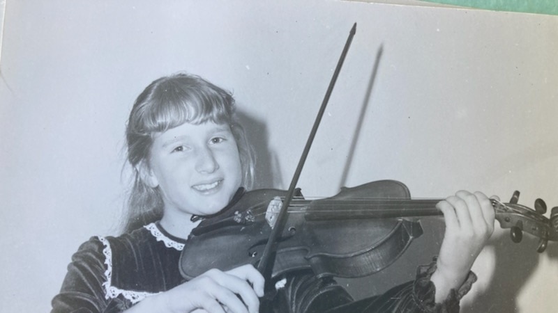 black and white image of young girl playing a violin