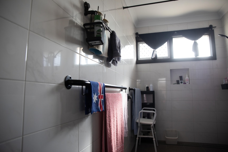 Andrew Fairbairn's bathroom with disability accessories including a shower chair.