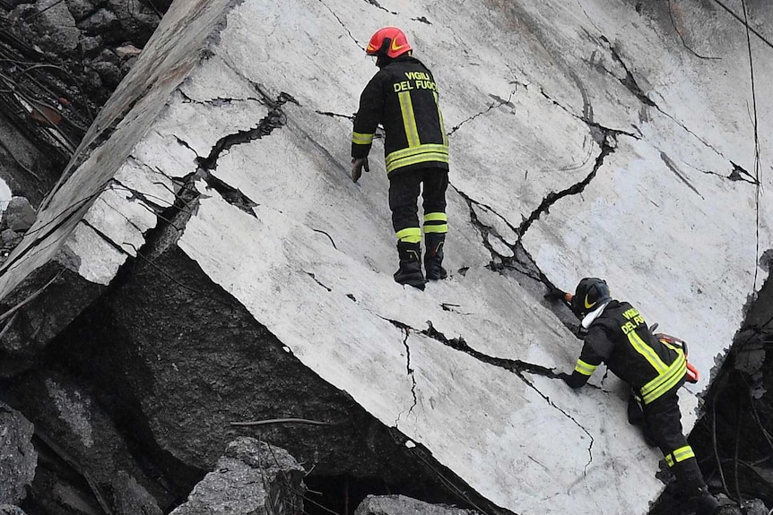 Rescuers work among the rubble of the collapsed Morandi highway bridge in Genoa.