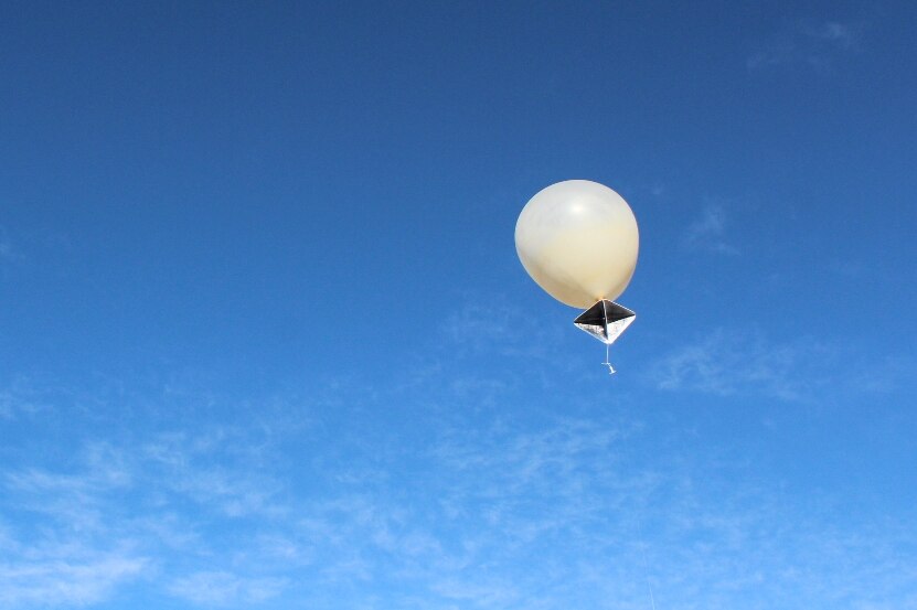 A weather balloon rises into the air.