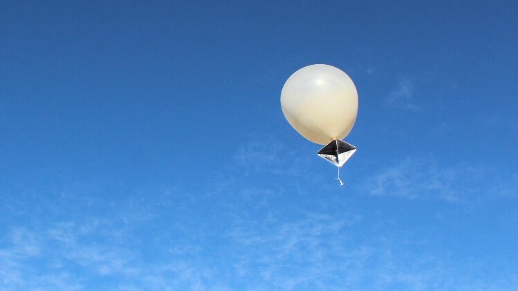 A weather balloon rises into the air.