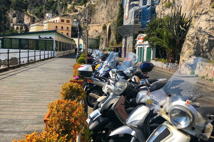 A row of scooters on an empty street in Amalfi