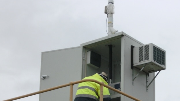 Technician checks dust monitoring equipment