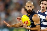 Adam Saad runs with a yellow football during Carlton's AFL match against Geelong.