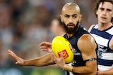 Adam Saad runs with a yellow football during Carlton's AFL match against Geelong.