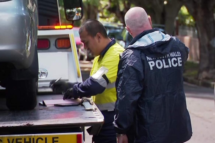 A police officer and a man next to a car