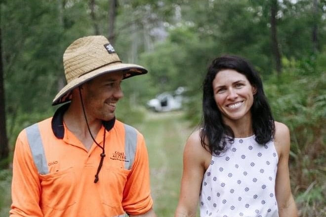 Man in hat, woman in dress hold hands