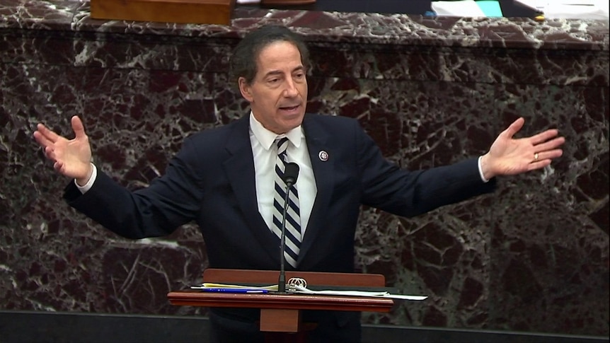 Raskin with his arms wide open, speaking at a lectern