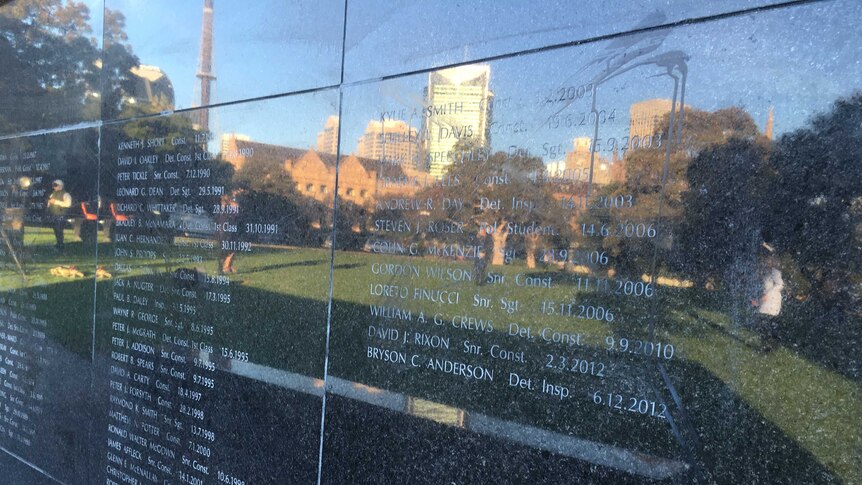 Black paint like substance on the wall of remembrance, engraved with names of police officers.