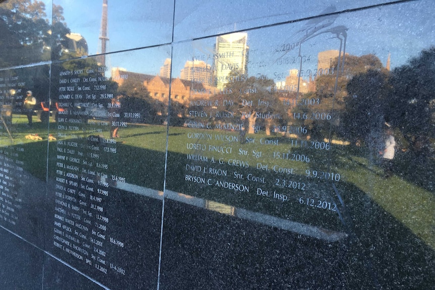 Black paint like substance on the wall of remembrance, engraved with names of police officers.