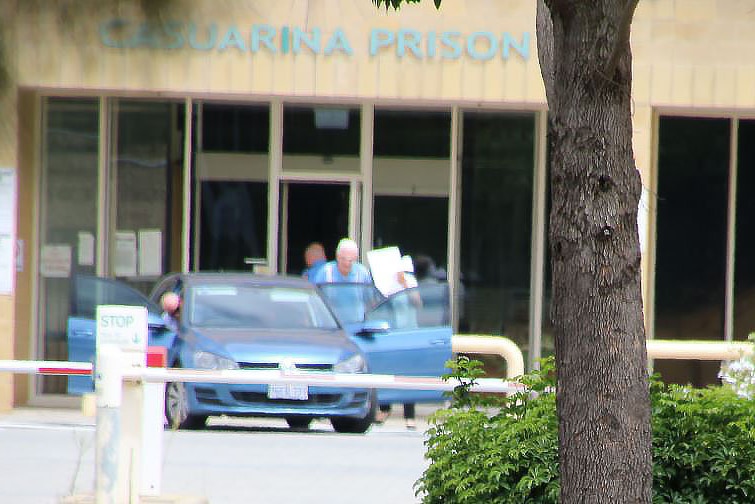 Harold Barclay gets into a small blue car in front of Casuarina's front entrance.