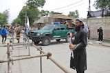 A Taliban guard standing with a gun on a street in Afghanistan.
