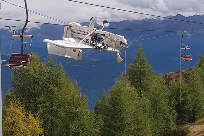 A light plane is tangled in chair lift cables, upside down in the Italian Alps.