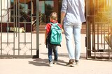 mum walking child into school through the front gate