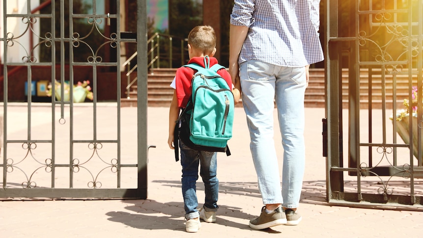 mum walking child into school through the front gate