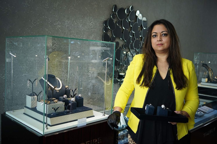 Shweta Kahn stands beside a display cabinet in her Starfire retail clothing store at Bulimba in Brisbane.