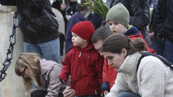 People light candles and place flowers in front of the Presidential Palace in Warsaw, Poland.