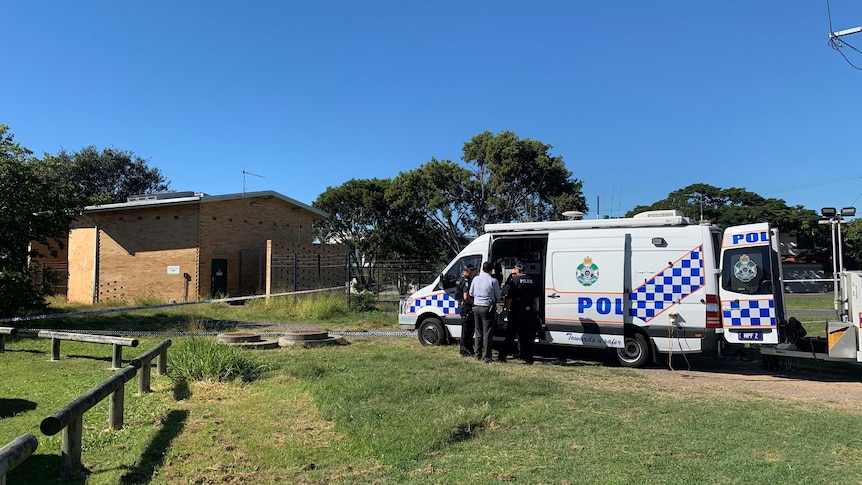 Police at the scene in Wynnum, with a major incident van and police tape around the sewage tank.