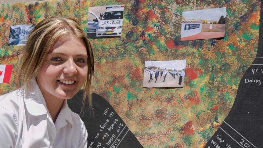 A teenaged girl's face in front of a paint spotted artwork dotted with pictures of police officers and cars