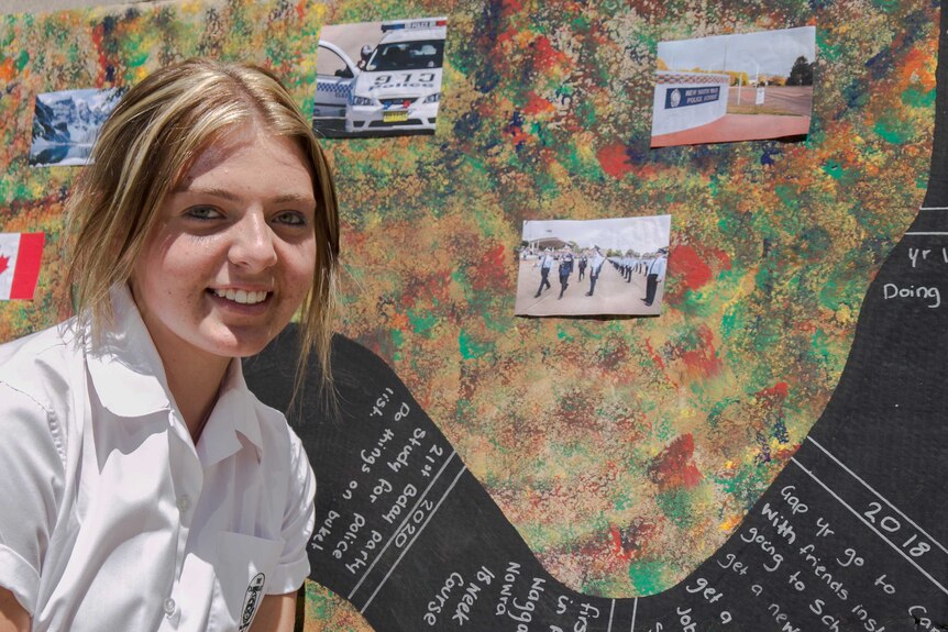 A teenaged girl's face in front of a paint spotted artwork dotted with pictures of police officers and cars