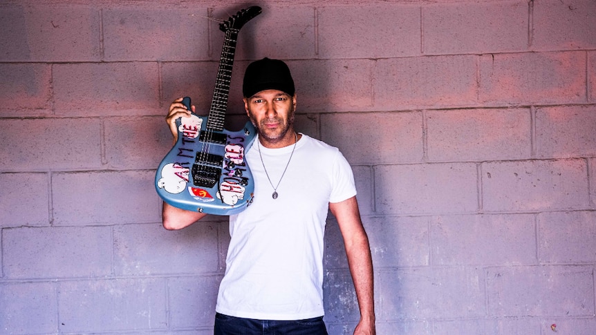 Press image of guitarist Tom Morello, holding up a guitar