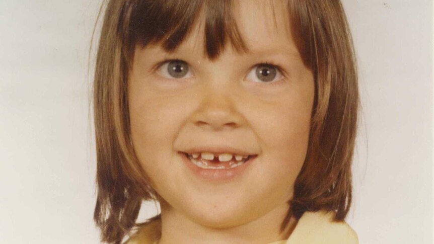 A six year old girl with a gap tooth smiles