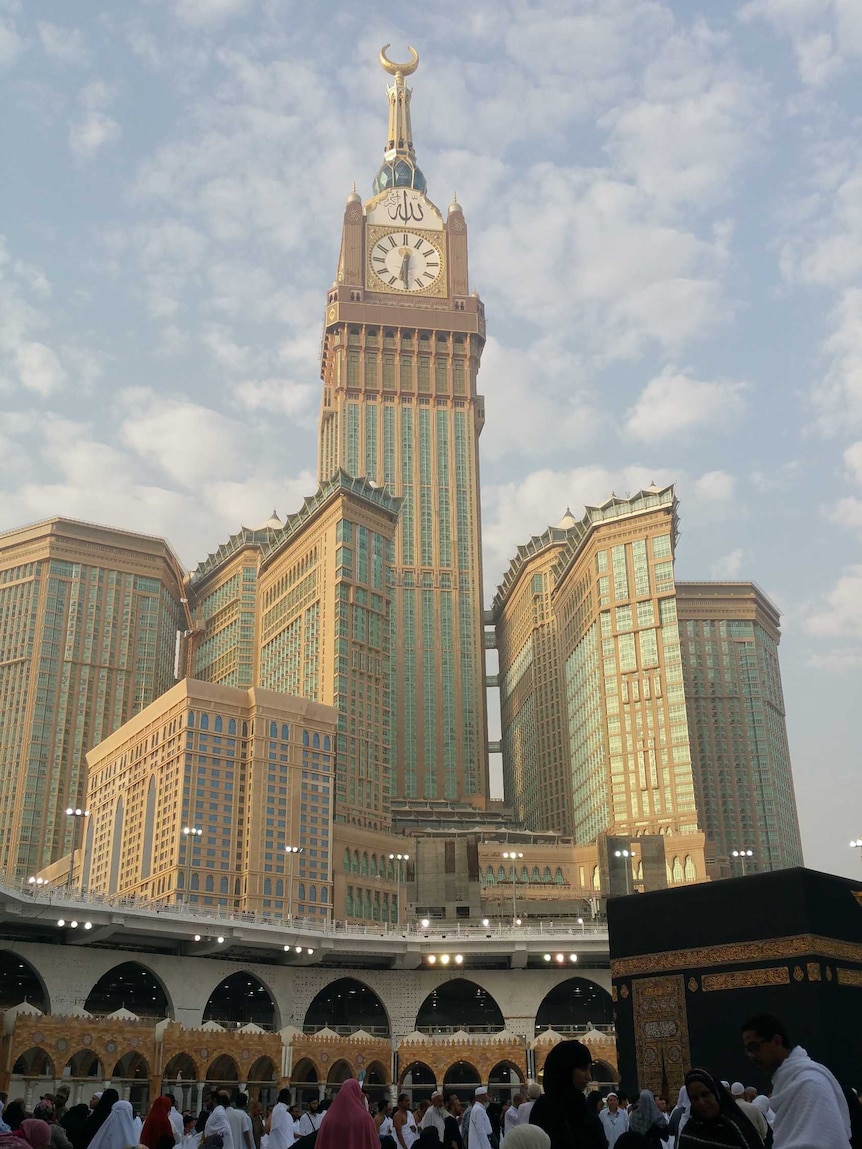 A tall building behind a black cube which believed by Muslims as a holy shrine.
