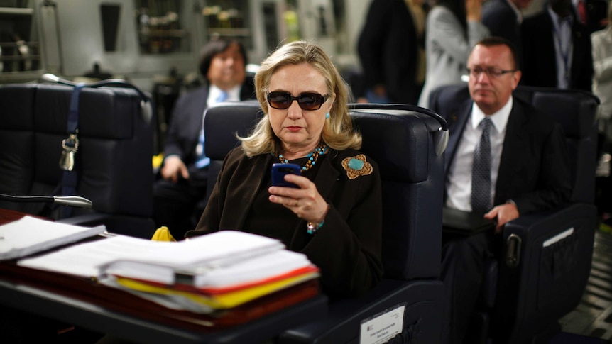 Hillary Clinton looks at mobile device