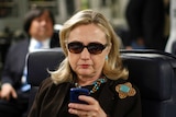 Hillary Clinton looks at mobile device