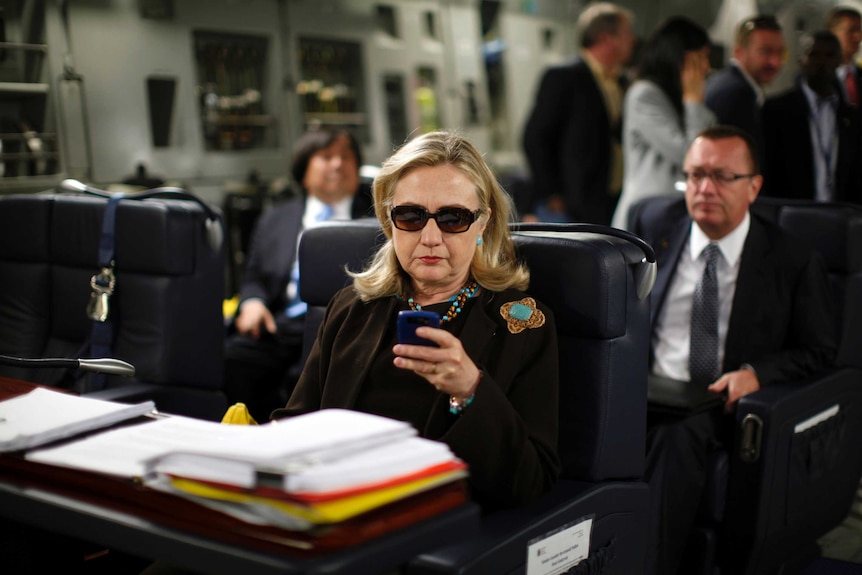 Hillary Clinton looks at mobile device