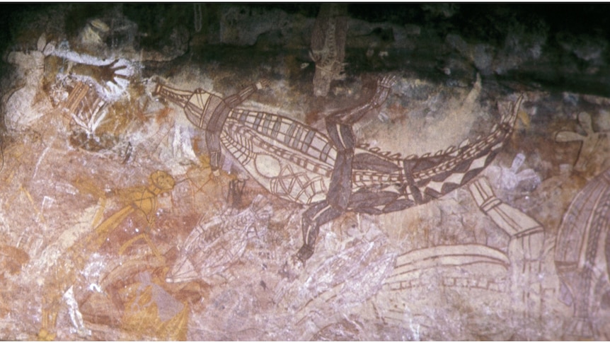 Large Aboriginal painting of a crocodile with two child hand stencils