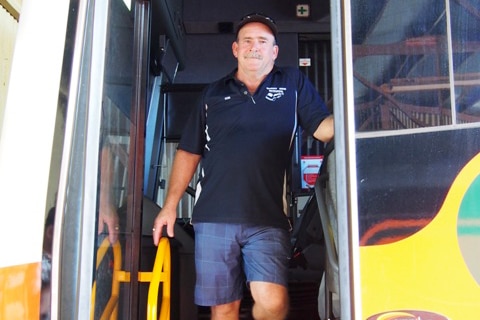 Don Dunbar stands on the step of a bus.