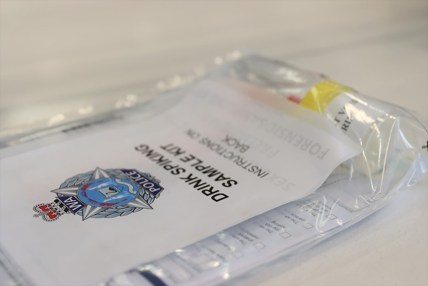 A self-test kit for drink spiking victims in a plastic sleeve with blue WA police logo.