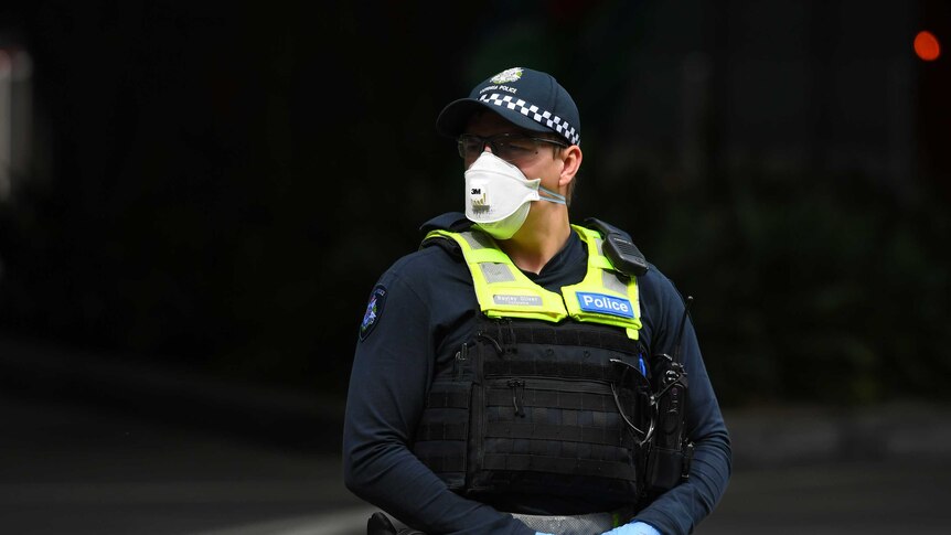 A male police officer in a face mask