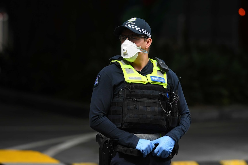 A male police officer in a face mask