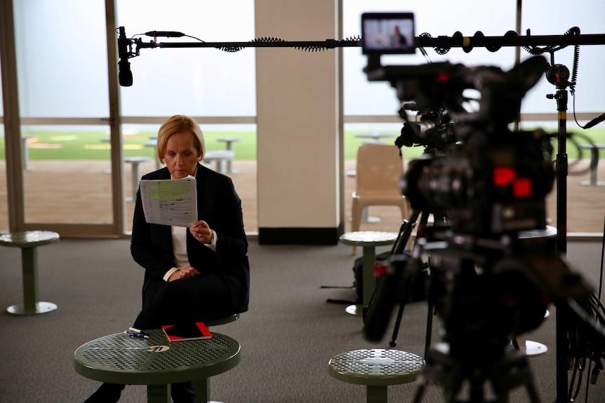 Ferguson sitting in prison visitors room surrounded by cameras and lights.