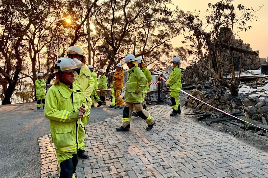 Пожарные у разрушенного коттеджа Пина-Бора в национальном парке Лэмингтон.