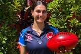Young female athlete holding AFL football