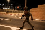 An Israeli soldier runs near the scene following a shooting incident at a check point in East Jerusalem.