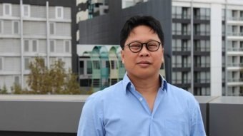 Robertus Robert stands on a rooftop in Melbourne