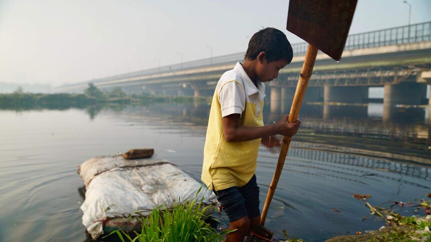 A boy on the bank of a river in New Delhi.