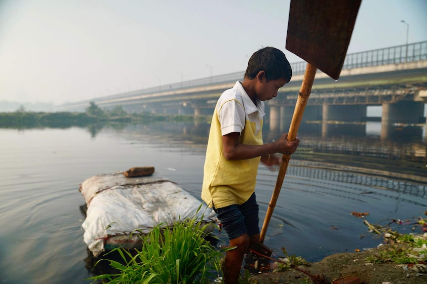 A boy on the bank of a river in New Delhi.