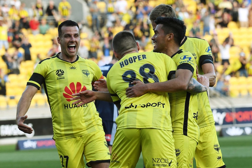 The Wellington Phoenix celebrate a goal against Melbourne Victory in the A-League.