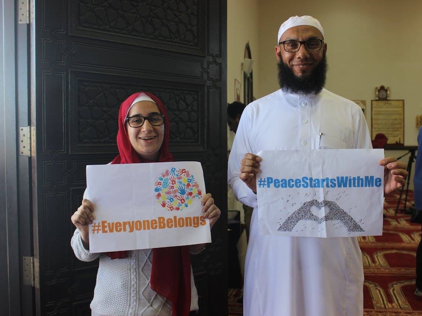Gaida Merei and Mohamad Abdalla hold signs promoting peace and unity with the community.